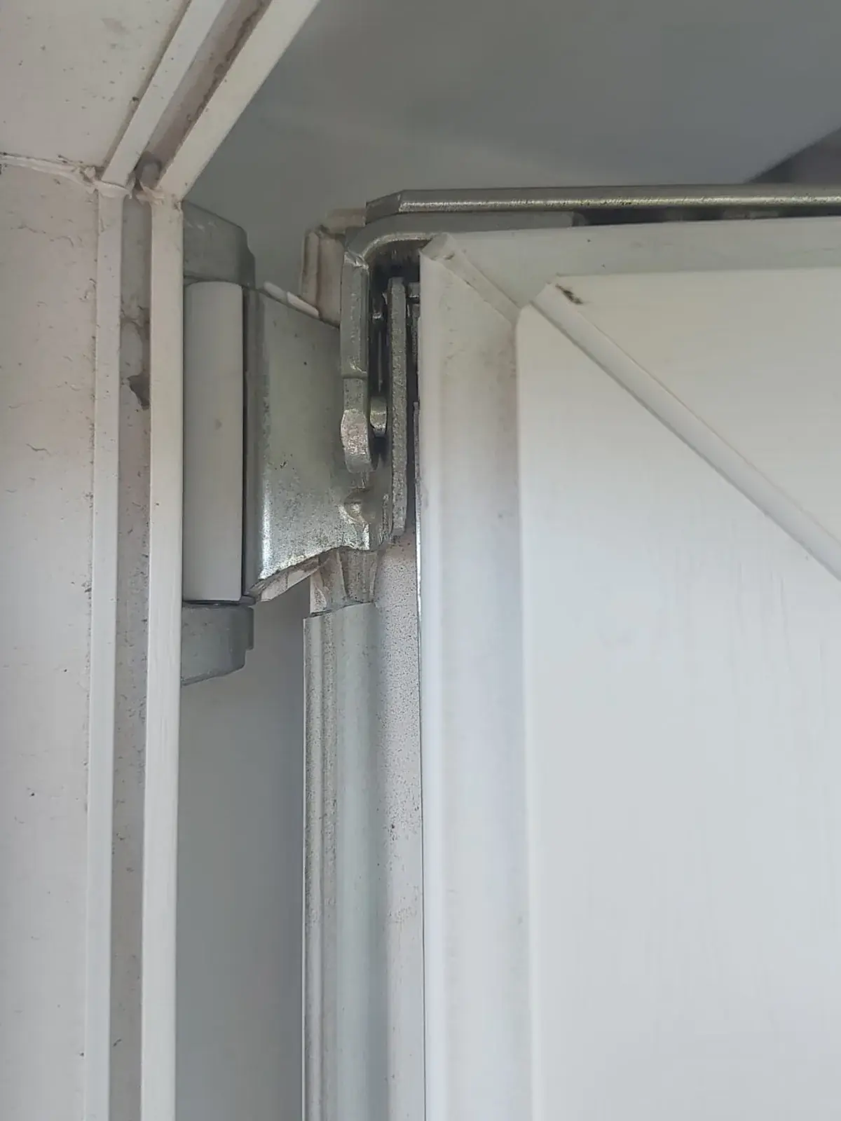 Paumelle haute d'une fenêtre PVC blanche vérifiée à Auderghem